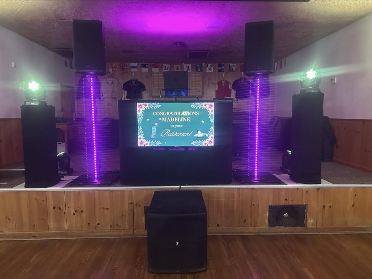 Hall setup with a screen, speakers, and purple lights